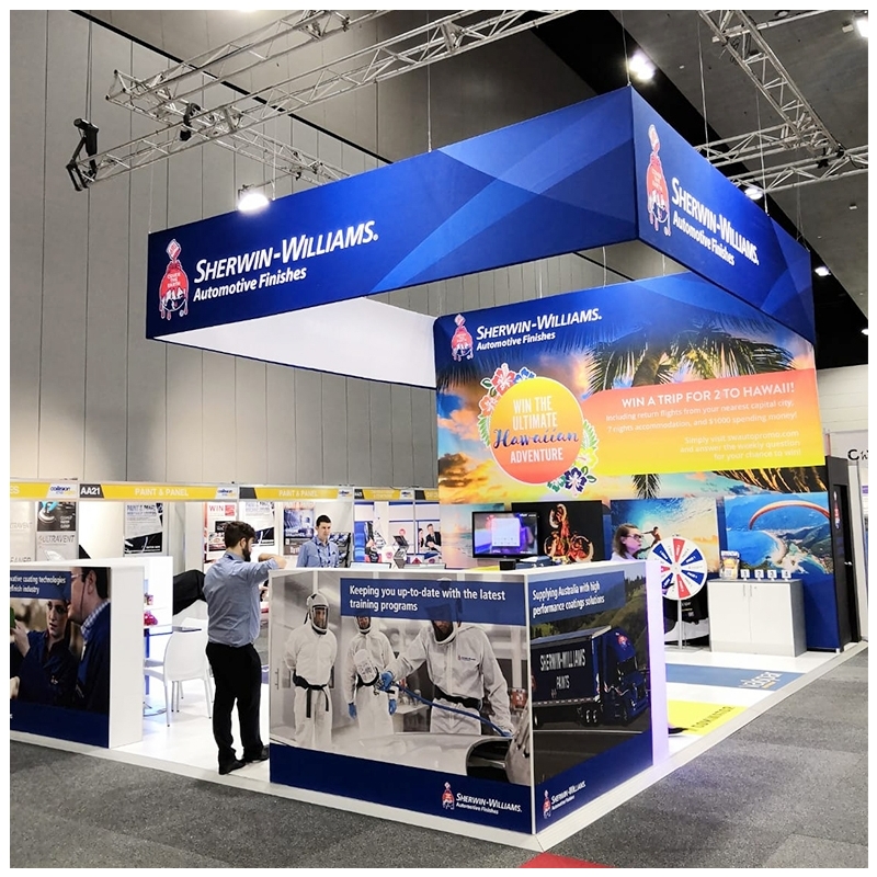 Custom printed rectangular exhibition hanging banner suspended above a branded exhibition stand